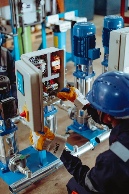Technician working on a pump skid control panel